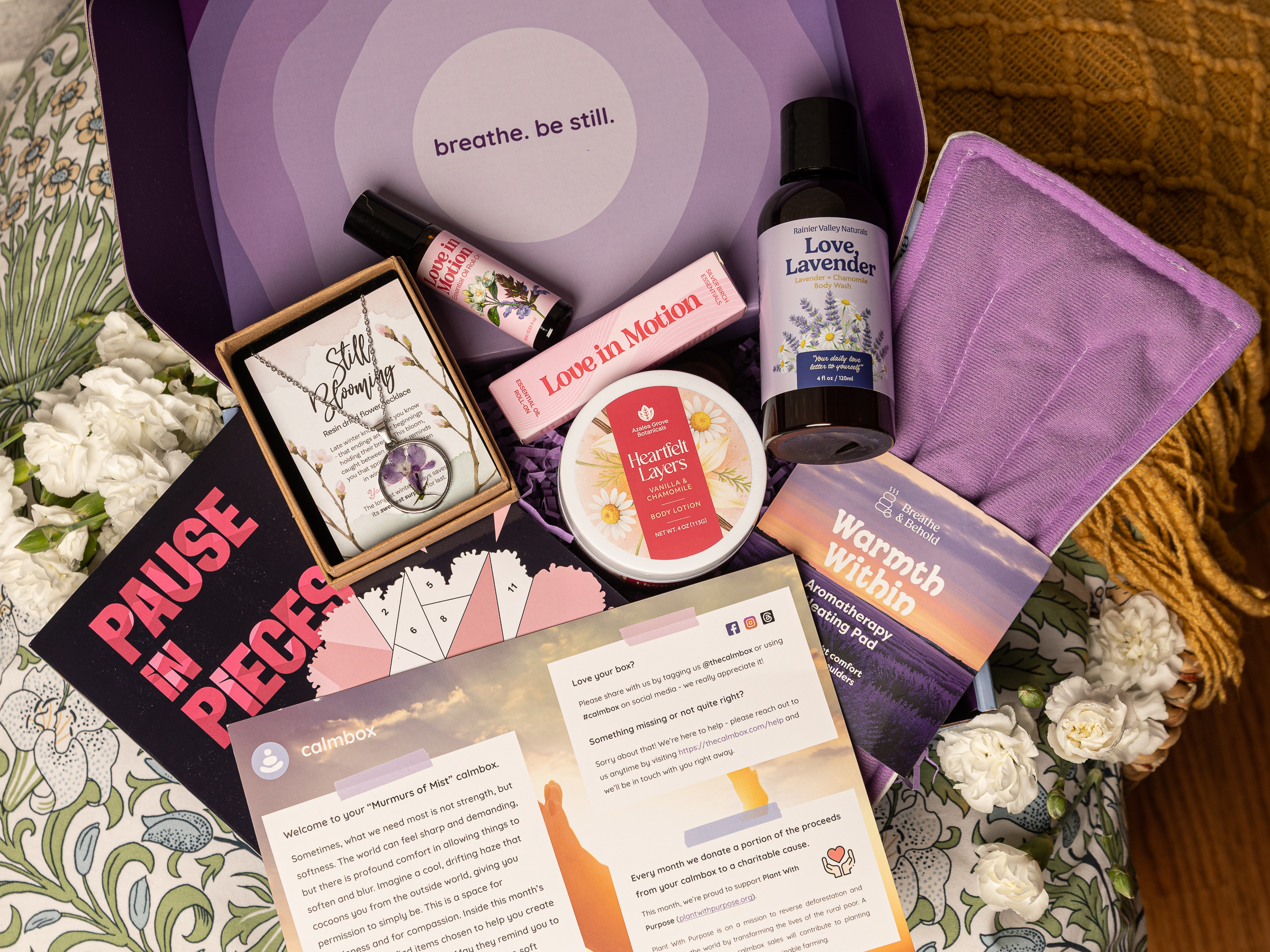 contents of the Murmurs of Mist calmbox - a lotion, oil, heating pad, sticker book, jewelry