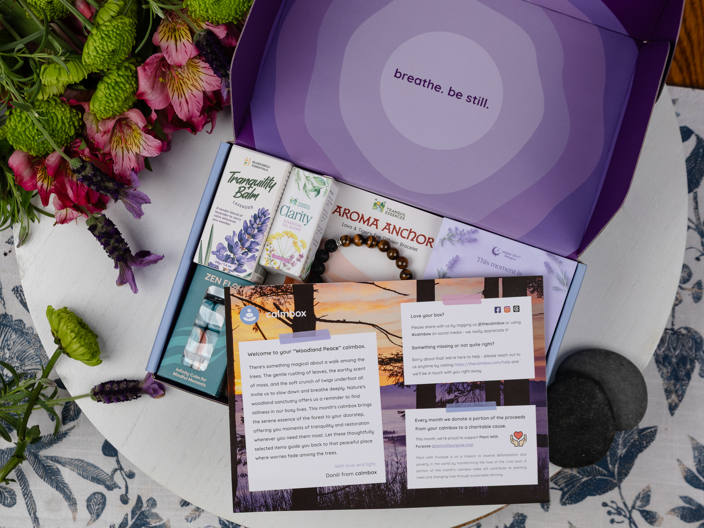 contents of the Woodland Peace calmbox - a candle, tote bag, bracelet, balm, and fidget cube